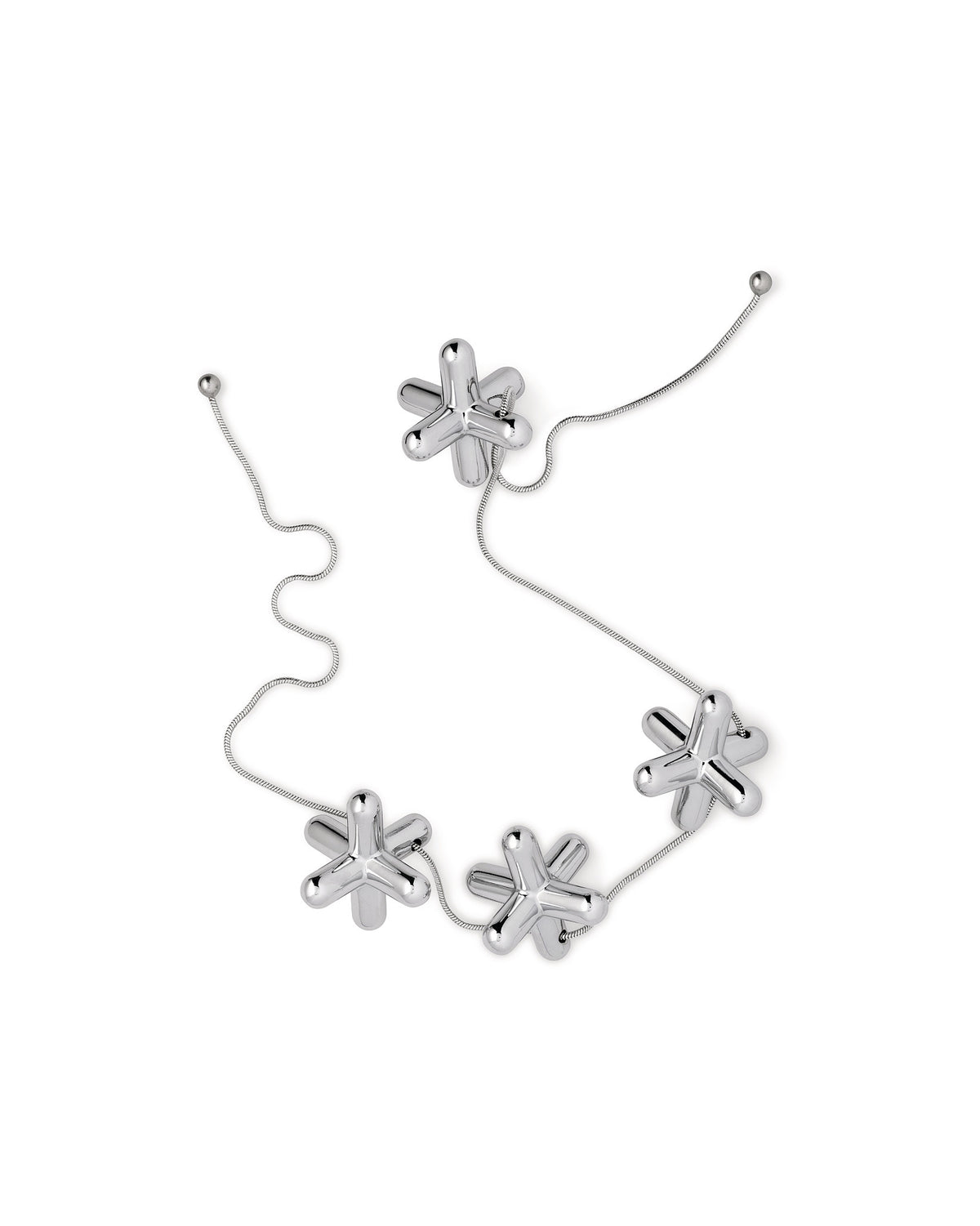 Tripod trivet by Alessi, composed of six reflective silver jack-like elements linked by a delicate chain.