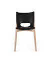 Black chair with light wood frame by Alessi, featuring a cutout backrest and sleek design.