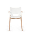 White and light wood chair by Alessi, with an oval cut-out in the backrest and wooden armrests.
