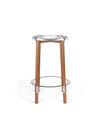 A modern bar stool by Alessi with a polished silver seat and light wood legs, featuring a metal footrest.