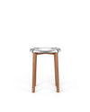 Modern stool with silver metal seat and wooden legs by Alessi, featuring a distinctive organic shape.