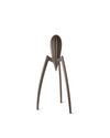Dark brown metallic citrus juicer by Alessi with a ribbed cone top and three sculptural legs.