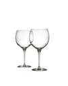 Two clear glass Mami XL wine glasses by Alessi with large bowls and long stems, standing side-by-side.