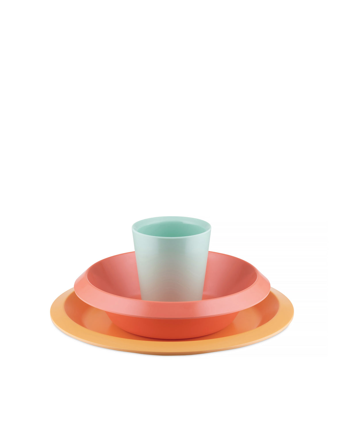 Colorful kids' tableware set by Alessi, with a light blue cup stacked in a coral bowl on an orange plate.