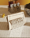 Silver-toned CACTUS! napkin holder by Alessi with abstract cutout design, alongside matching cruet set holder and bowl on a striped tablecloth.