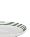White ceramic plate by Alessi with three watercolor-style green stripes, viewed from a close angle.