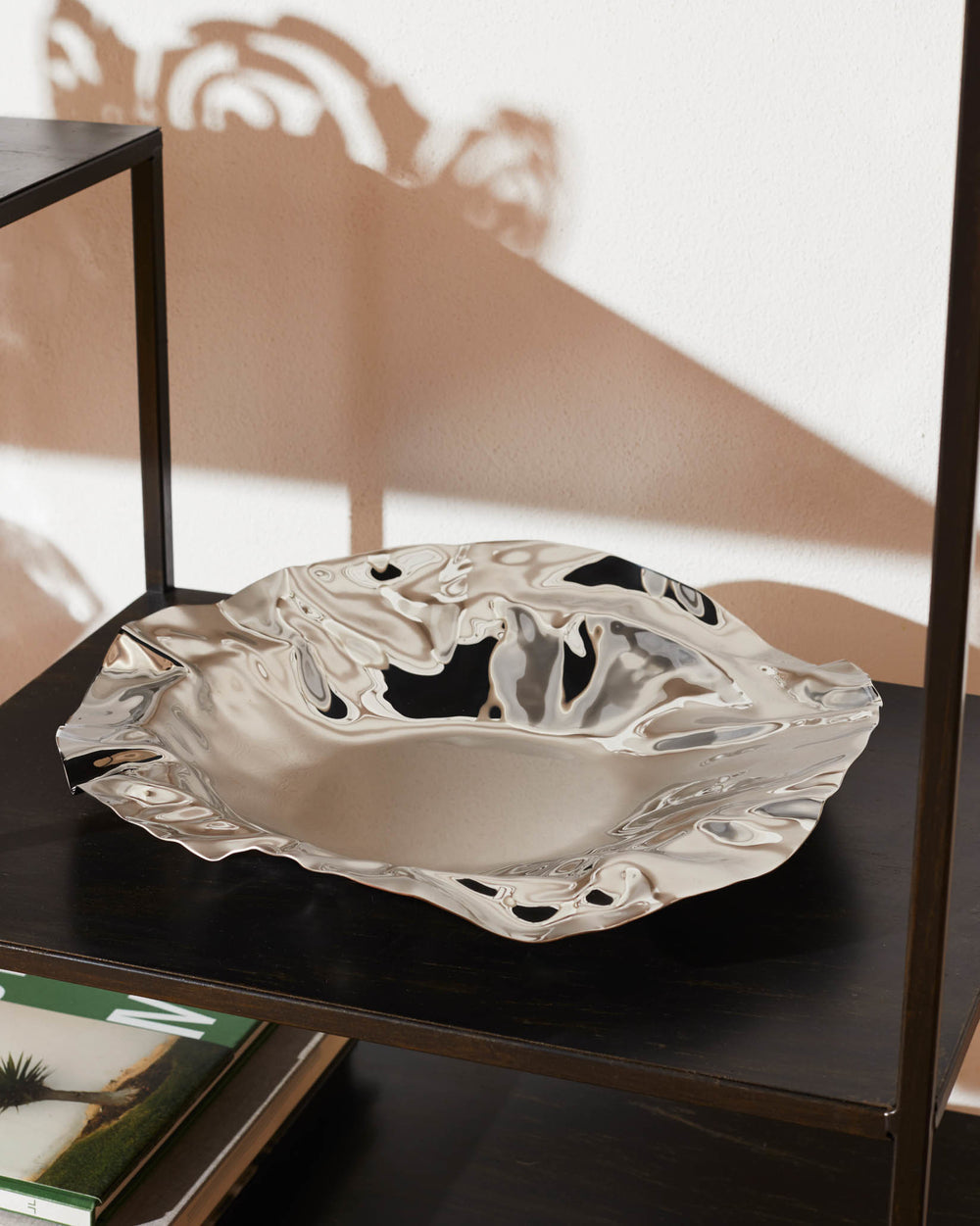 Silver metallic wavy Port bowl by Alessi, highly reflective.