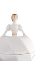 White porcelain bride figurine container by Alessi, with rose gold hair and sleeve accents, serving as a lid.