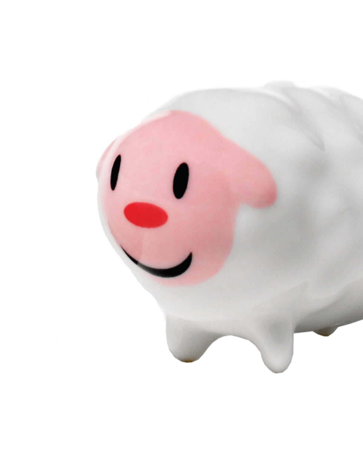 White sheep figurine by Alessi with a pink face, red nose, black eyes, and a smile, viewed from the front-side.