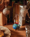 White and red hot air balloon ornament by Alessi, with a grid pattern and red jewels, hanging from a silver chain.
