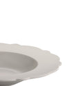 Light grey scalloped plate by Alessi, shown in a close-up, top-down view.