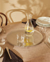 Round silver Veneer platter by Alessi with wavy woodgrain pattern reflecting lemons.