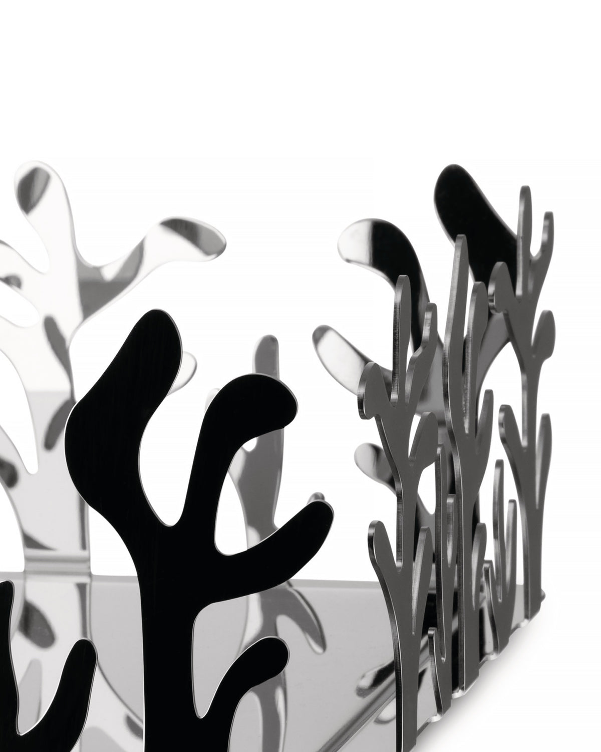 Silver reflective fruit bowl by Alessi featuring an intricate, coral-like cut-out design.