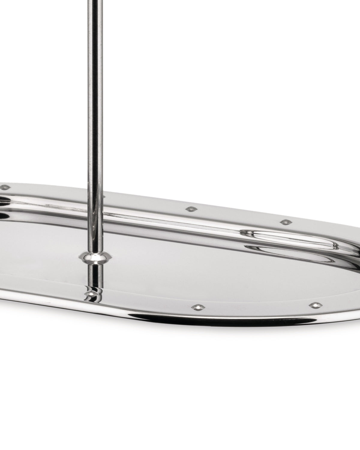 Cropped view of a polished metal oblong serving tray by Alessi, with a central rod and decorative studs.
