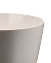 Light gray stoneware bowl by Alessi with a matte speckled exterior and glossy off-white interior, cropped side view.