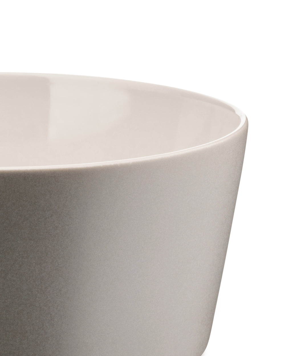 Light gray stoneware bowl by Alessi with a matte speckled exterior and glossy off-white interior, cropped side view.