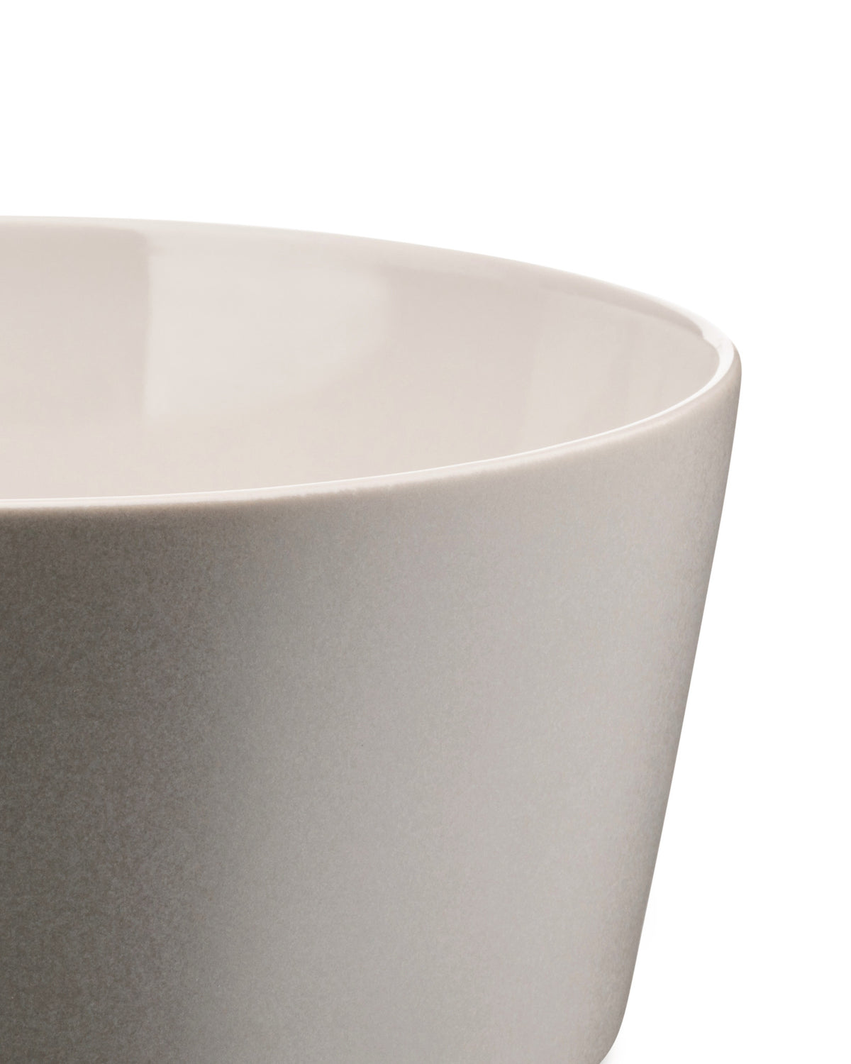 Light gray stoneware bowl by Alessi with a matte speckled exterior and glossy off-white interior, cropped side view.