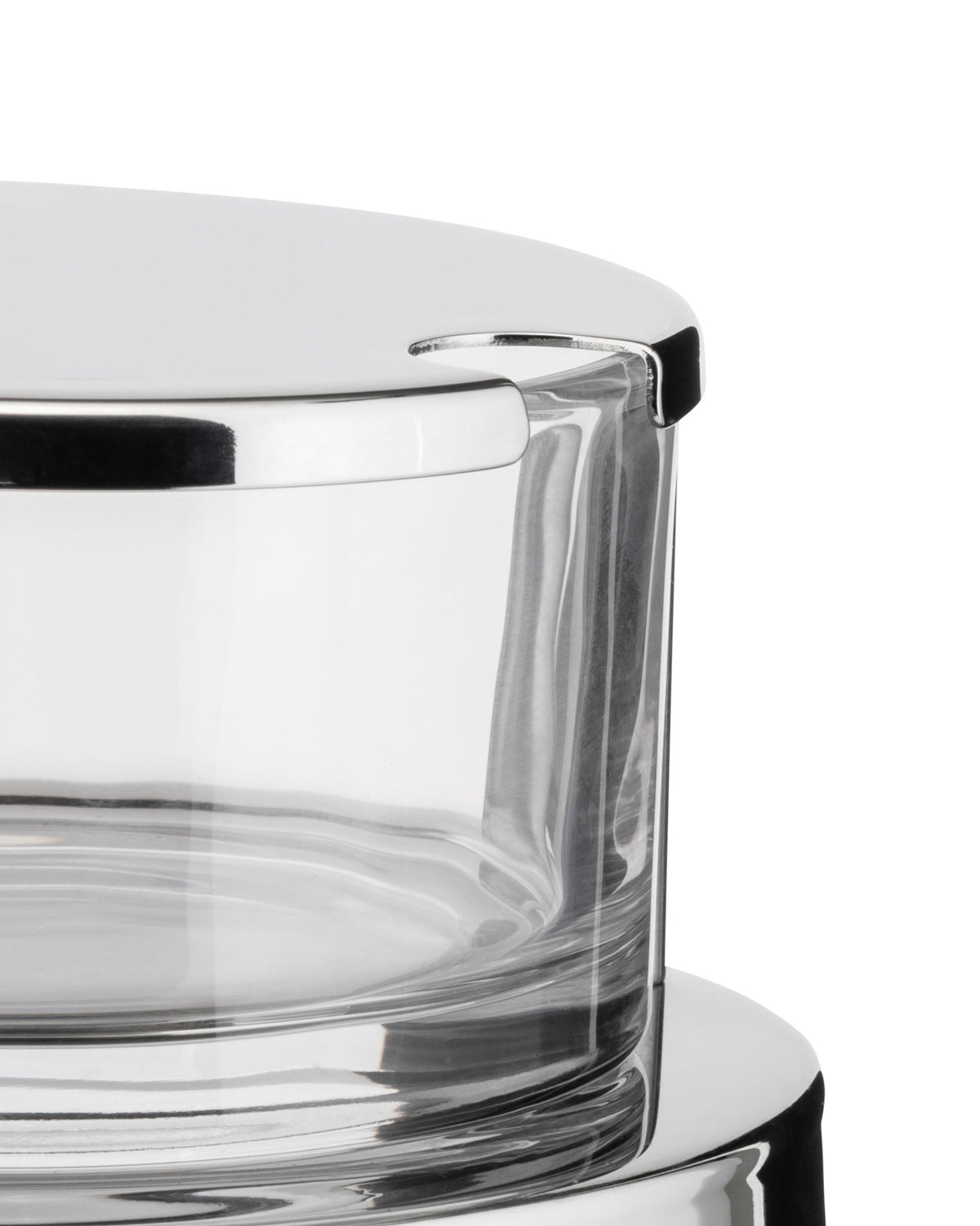Chrome and glass cheese cellar by Alessi with a shiny reflective lid and clear container, cropped view.