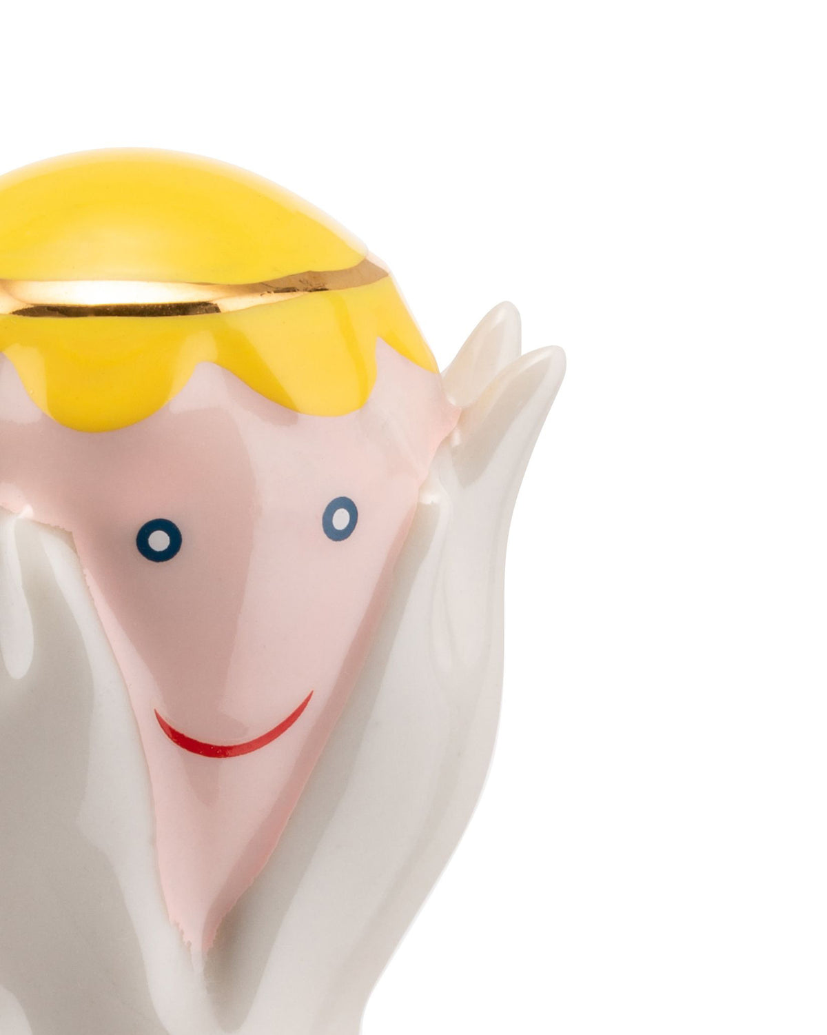 Yellow-haired ceramic Angelo Miracolo figurine by Alessi with a gold band, pink face, blue dot eyes, red smile, and white hands.