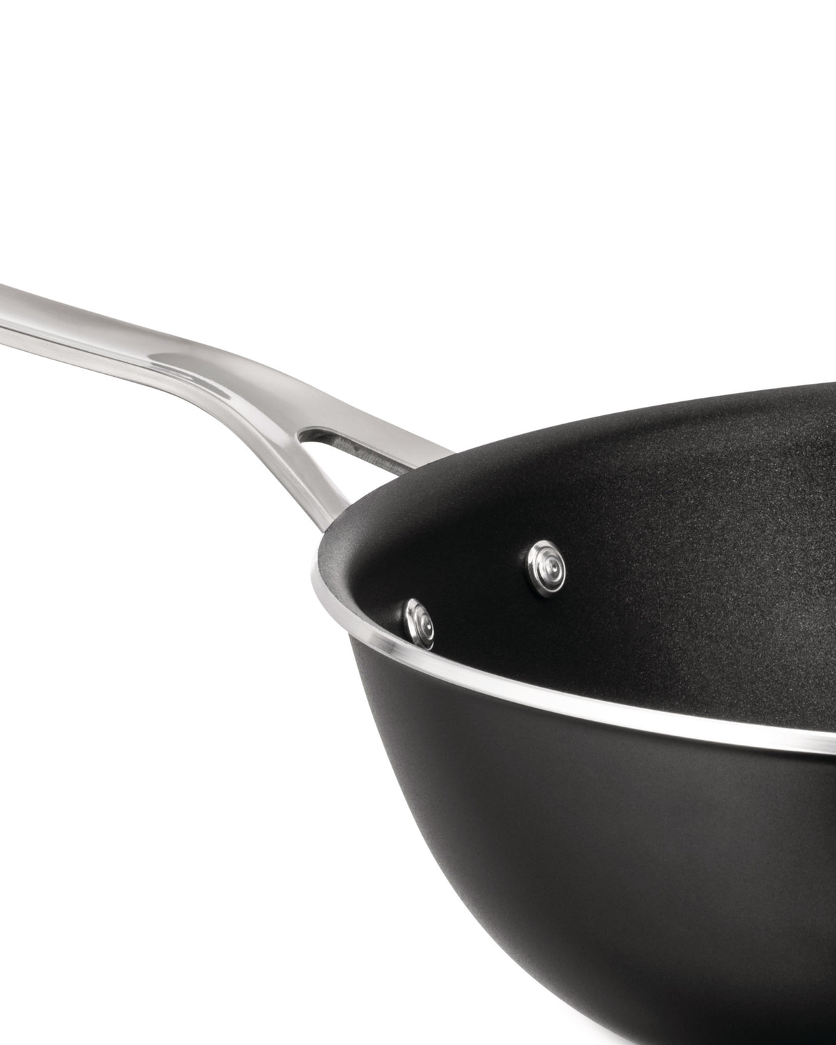 Black non-stick pan by Alessi with a polished silver handle and rim, shown in an angled close-up.