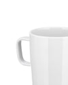 White ceramic mug by Alessi with a glossy finish and curved handle, cropped close-up.