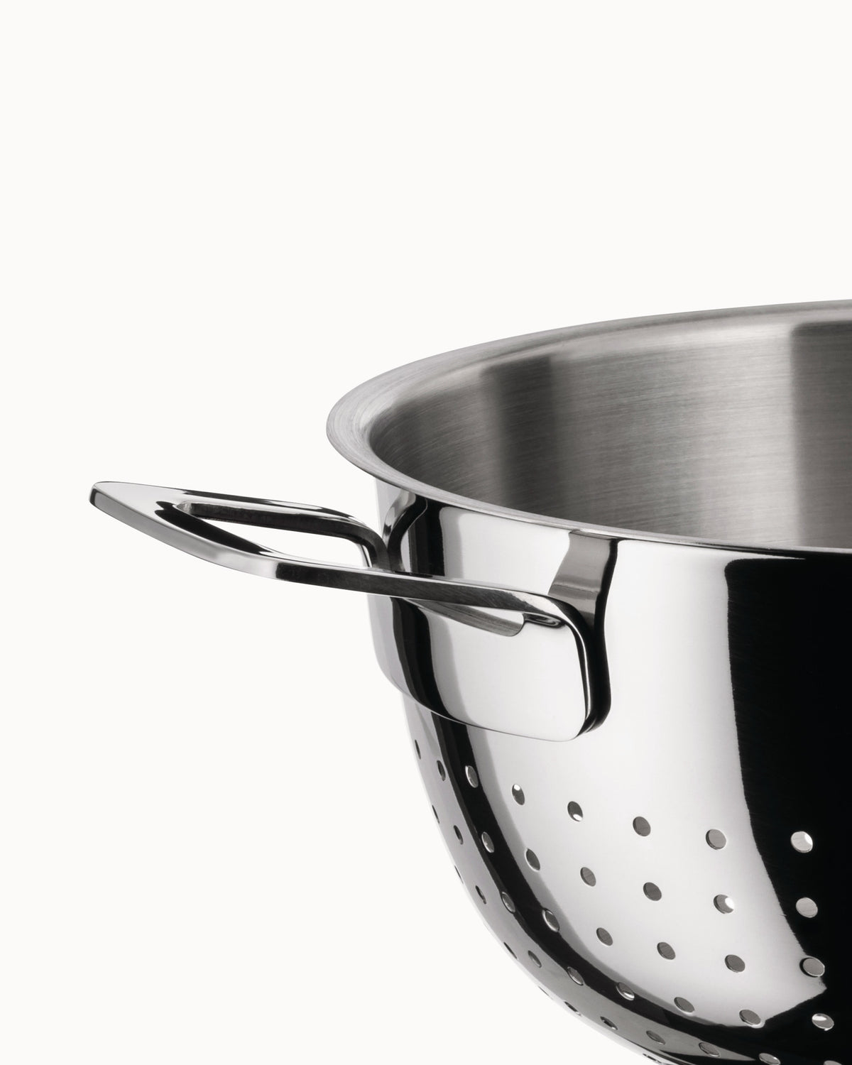 Shiny stainless steel colander by Alessi with a sleek handle and perforated holes, close-up side view.