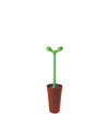 Green sprout-shaped toilet brush by Alessi, displayed in a reddish-brown pot.