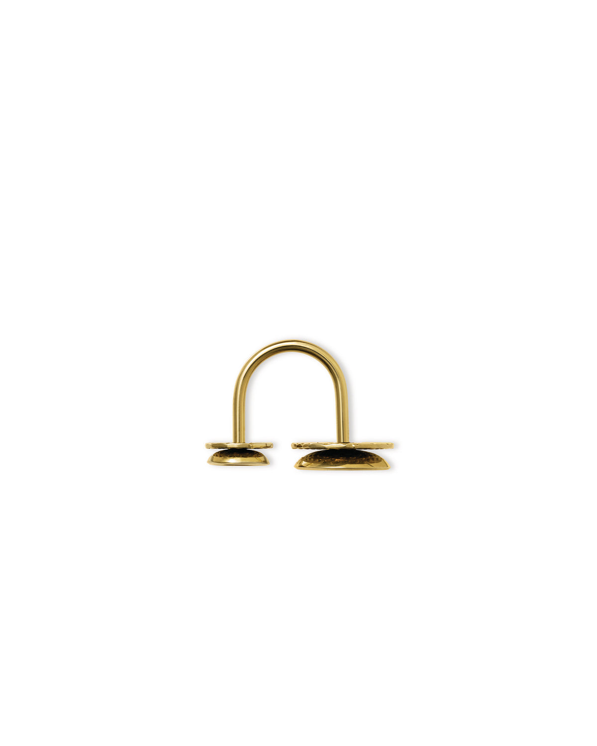 Gold Acta by Alessi, a U-shaped metal object with two textured flat bases on a white background.