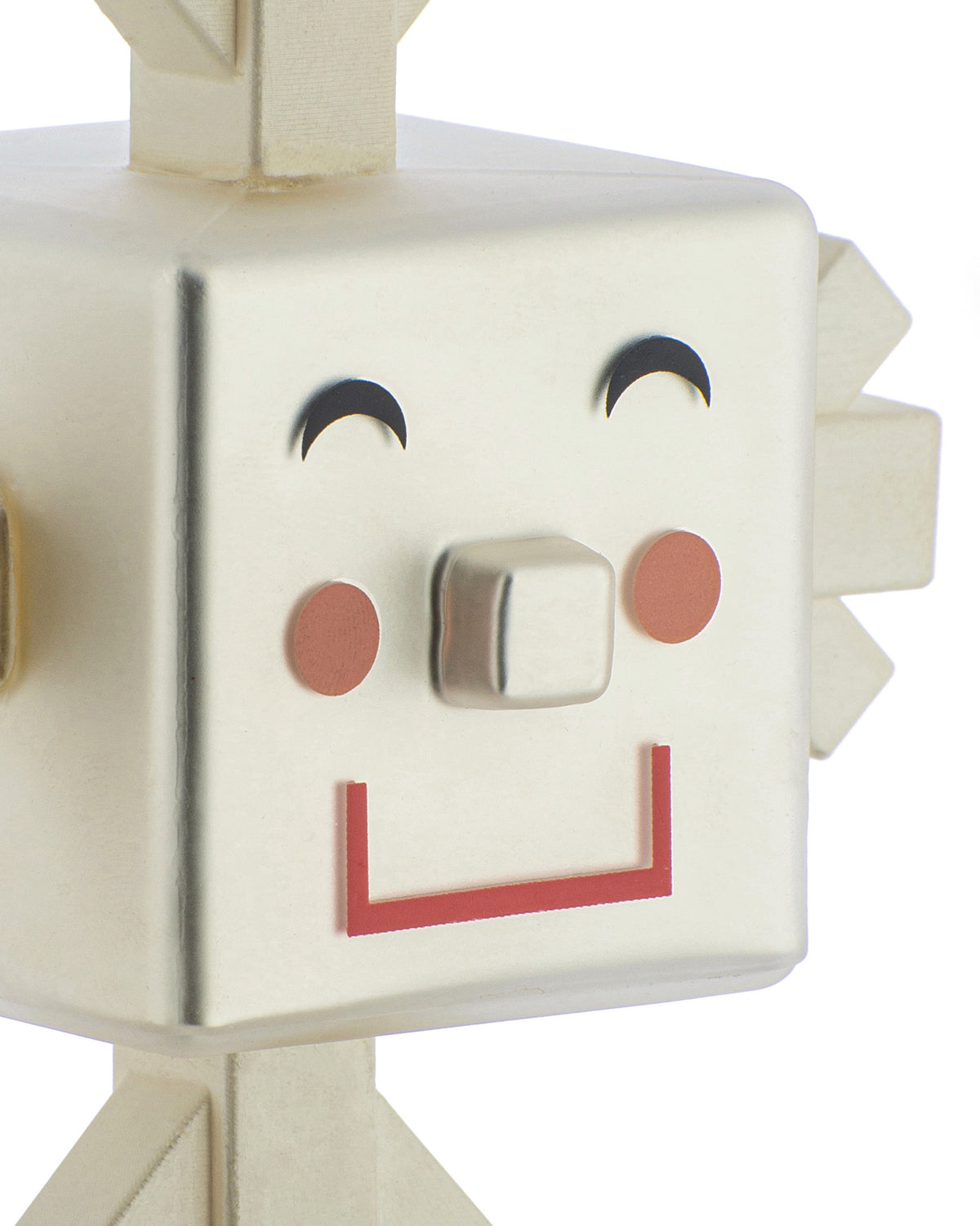 Creamy white geometric character figurine by Alessi with a smiling face, metallic nose, and red mouth.