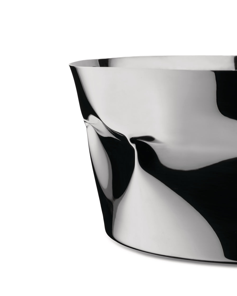 A silver sculptural bowl by Alessi, with a highly reflective, crumpled metal surface showing abstract black and white forms.