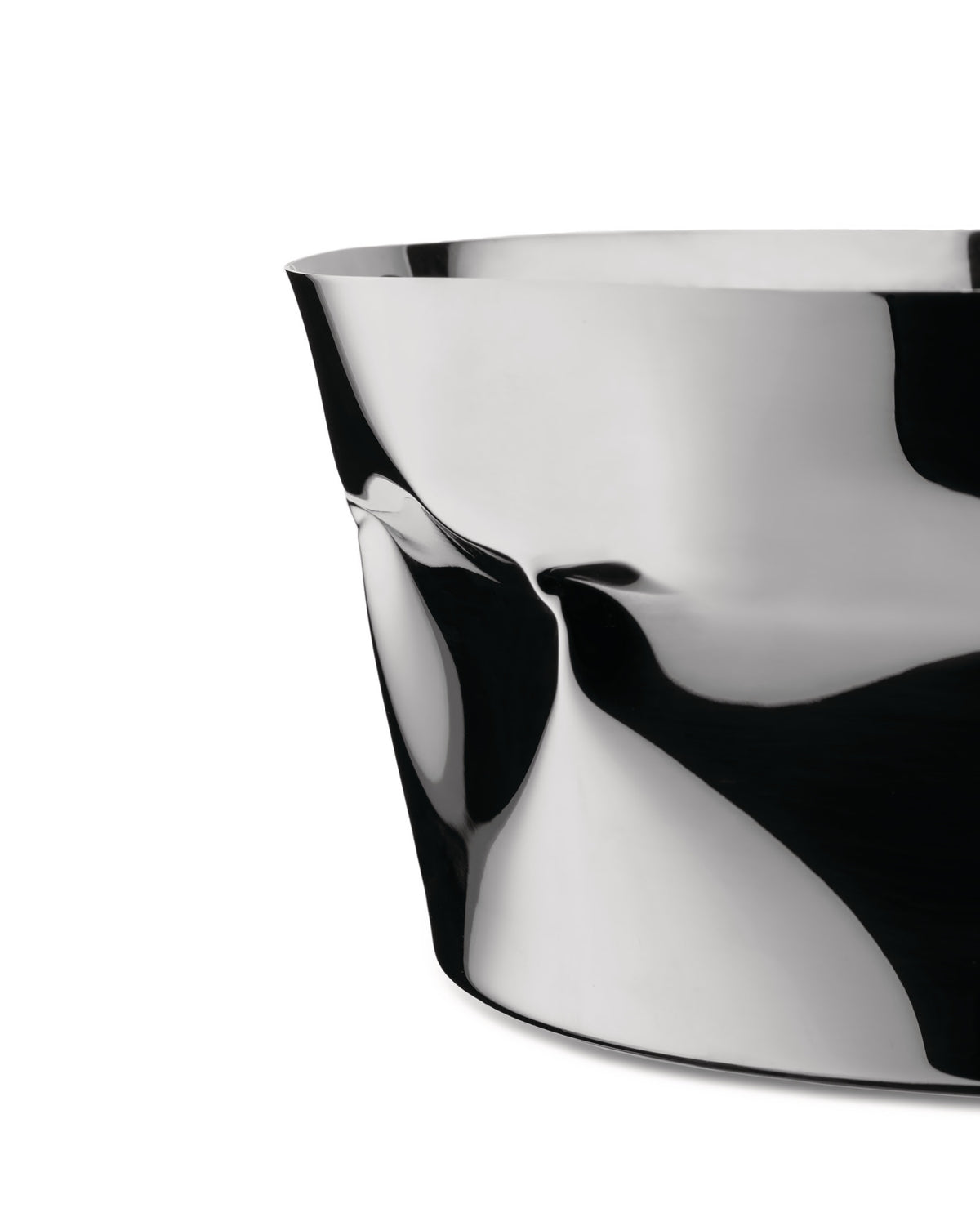 A silver sculptural bowl by Alessi, with a highly reflective, crumpled metal surface showing abstract black and white forms.