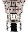 White and silver decorative hot air balloon by Alessi, with red jewels, black grid, and silver chains to a wavy base.