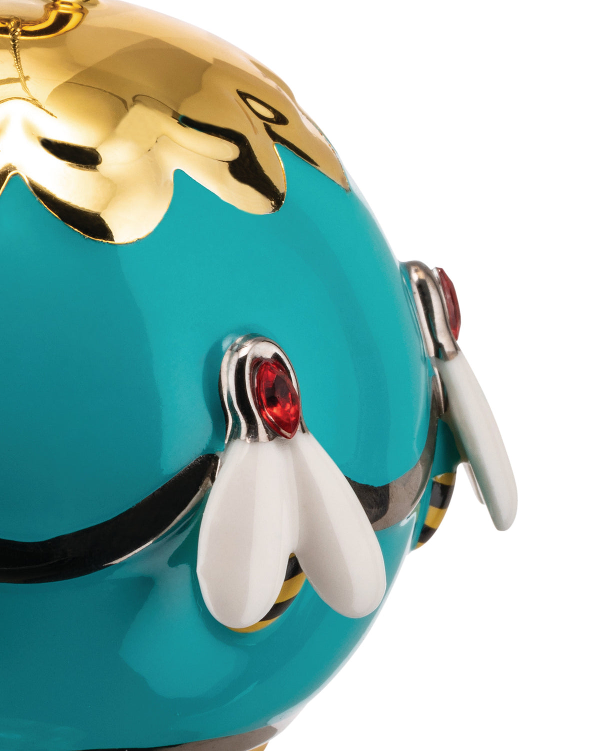 Glossy teal and gold decorative ornament by Alessi, with a dripping top and three bees featuring red jewel eyes and white wings.