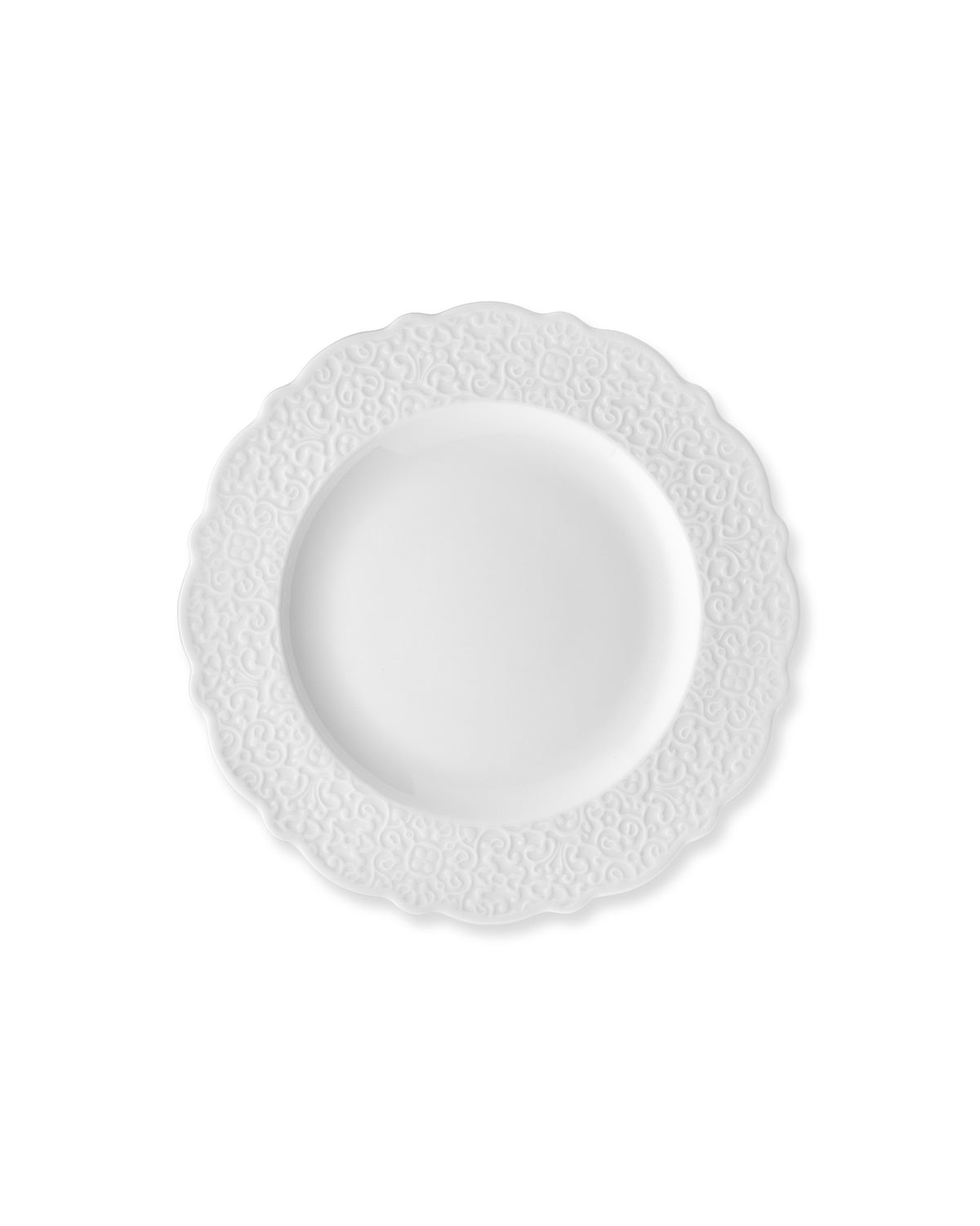 White plate by Alessi with a scalloped edge and embossed scroll pattern.