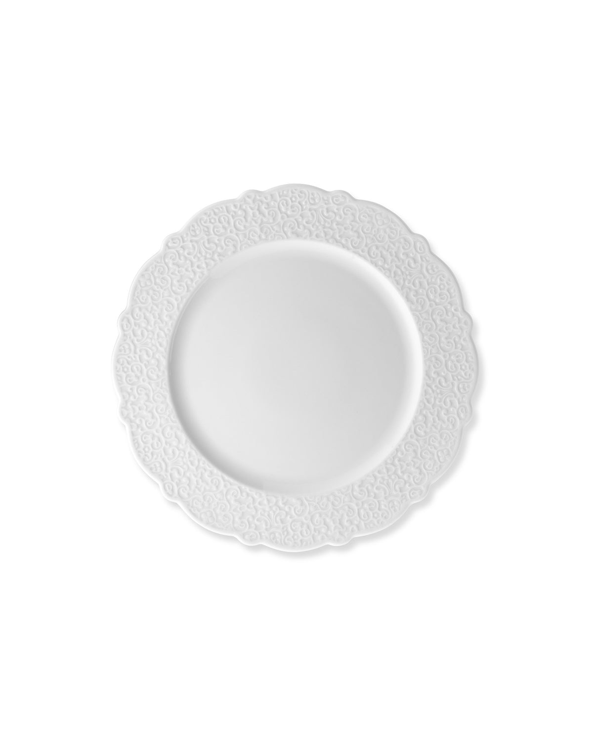 White plate by Alessi with ornate embossed swirl patterns and scalloped edges.