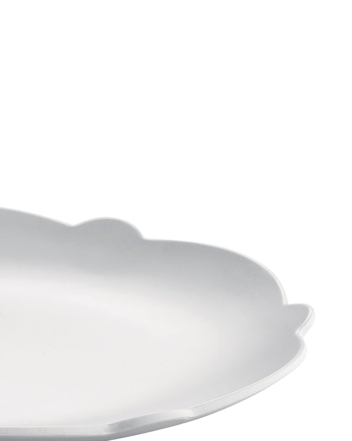 White scalloped serving platter by Alessi, with a matte finish, in a cropped, angled view.