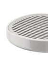 White slotted soap dish by Alessi with a metallic draining top, in a close-up angled view.