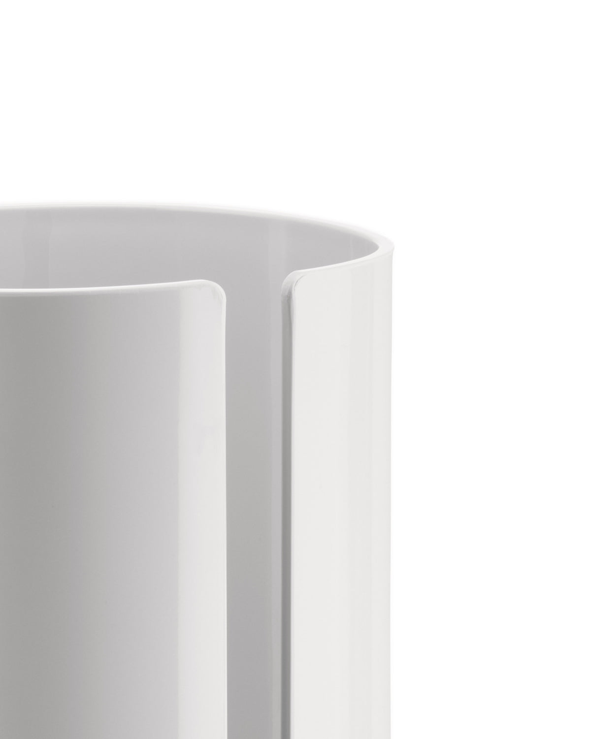 White cylindrical holder by Alessi with a vertical slot, showing a smooth, glossy finish.