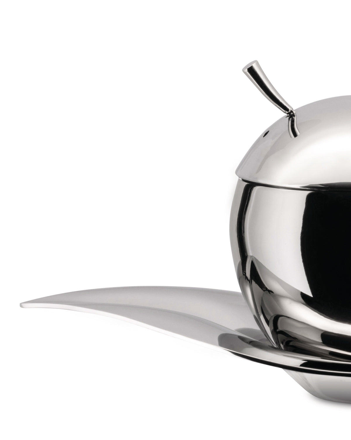 Polished stainless steel oil cruet by Alessi, sphere-shaped with a curved spout, on a leaf-shaped tray, cropped side view.