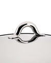 Polished stainless steel Mami cookware lid by Alessi, featuring a sleek, curved arch handle and its reflection.