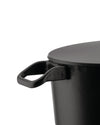 Black cooking pot with lid by Alessi, close-up showing a textured finish and short handles.