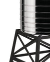 Silver polished Water Tower by Alessi with grooved cylinder on a black geometric stand, close-up.