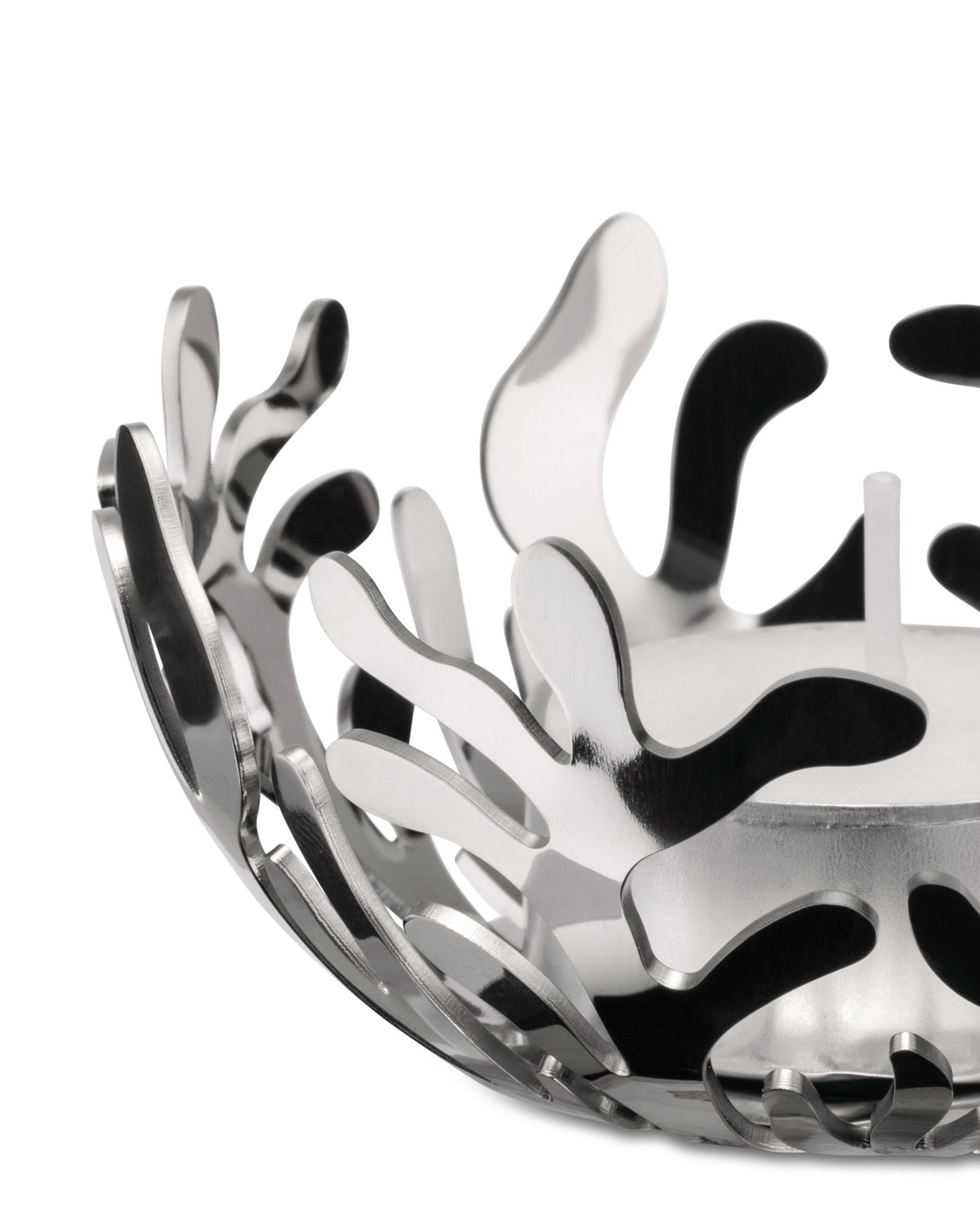 Silver metallic tealight holder by Alessi with intricate organic coral cutouts, holding a white candle.