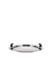 A round polished metal serving tray by Alessi with a perforated rim and black handles.