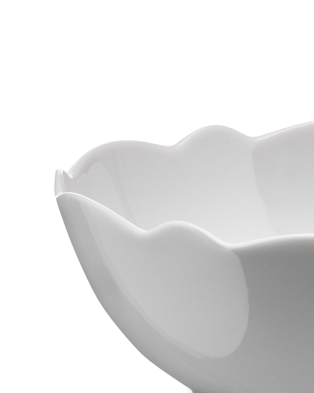 White serving bowl by Alessi with an elegant wavy rim, angled view.