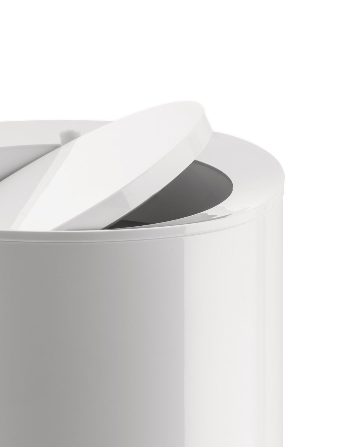 Glossy white modern container by Alessi with its round lid partially open, revealing a dark interior.