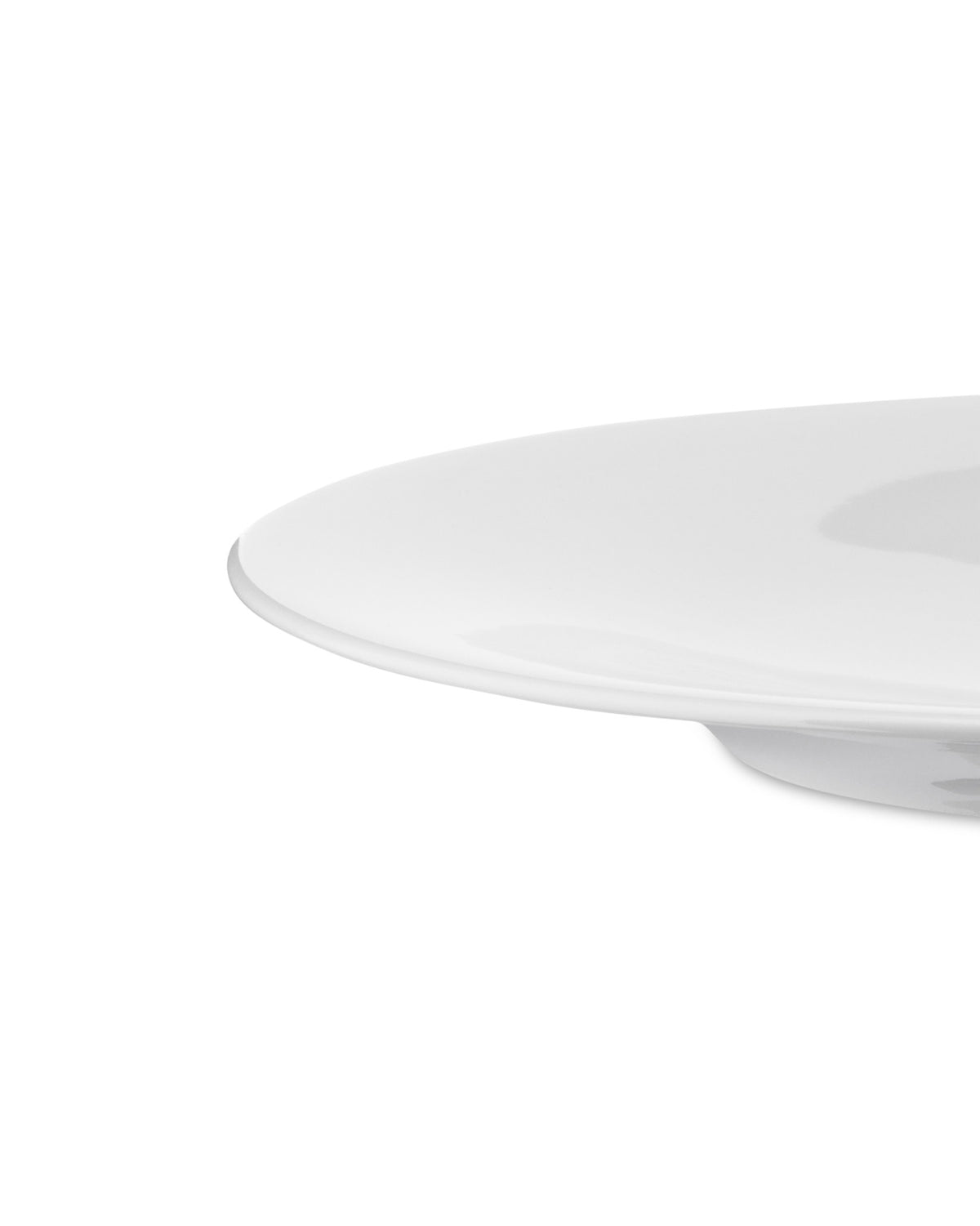 White plate by Alessi with a smooth, glossy surface, captured from a low, cropped side angle.