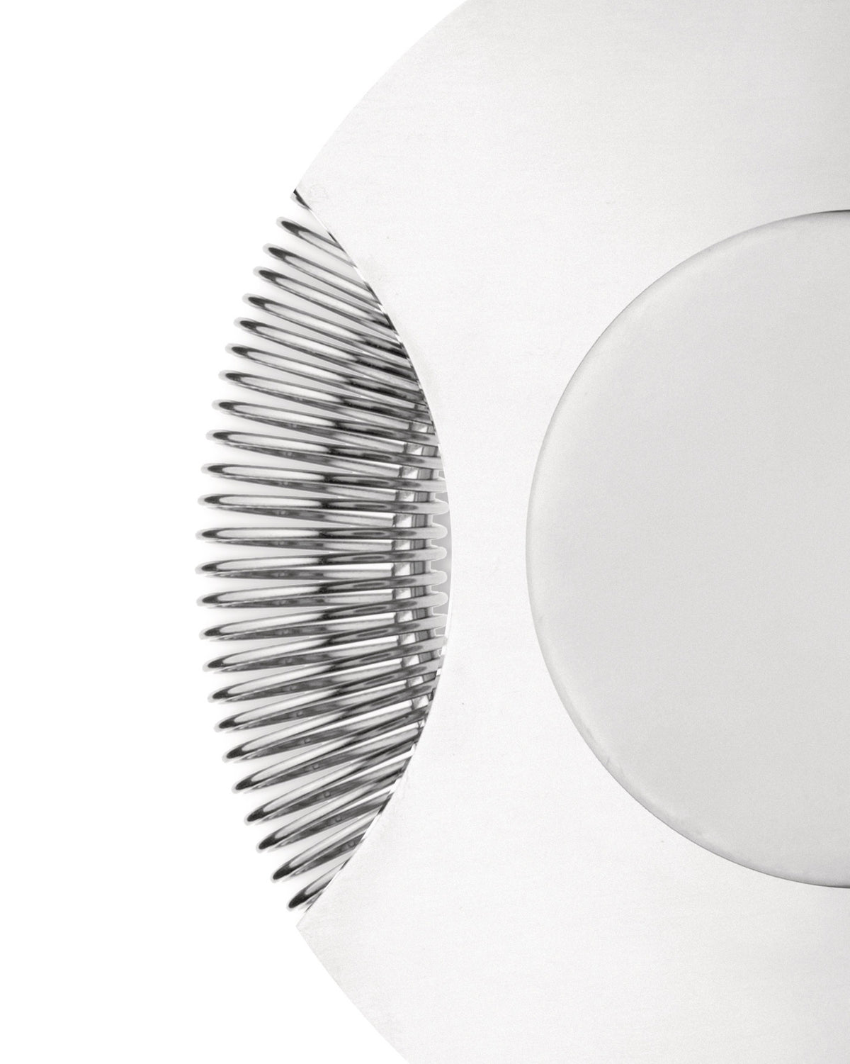 The tending box with silver metallic ribs and a smooth white curve by Alessi, in a cropped, abstract close-up.