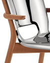 Curved wooden chair with a polished chrome seat by Alessi, featuring a sculptural cutout and smooth armrest in a close-up.