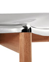 Shiny metallic and wood chair by Alessi, featuring a smooth curved seat and a round leg.